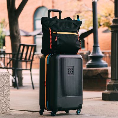 Устойчивый чемодан с антиразбивающей внешней сетчатой компрессионной панелью и компрессионным ремнем, предназначенным для беззаботного передвижения